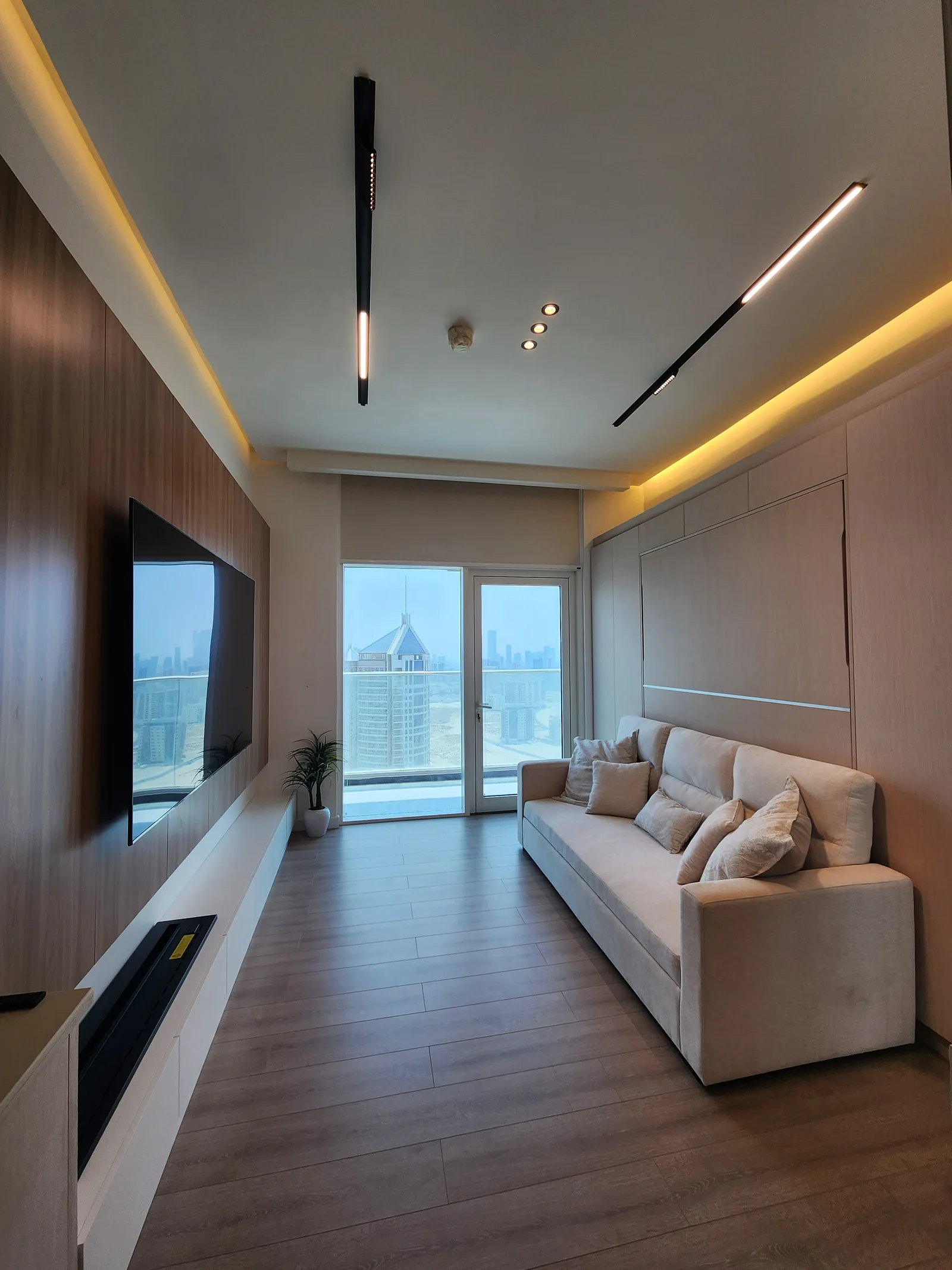 The same living room with the linear ceiling lights and concealed light line switched on.