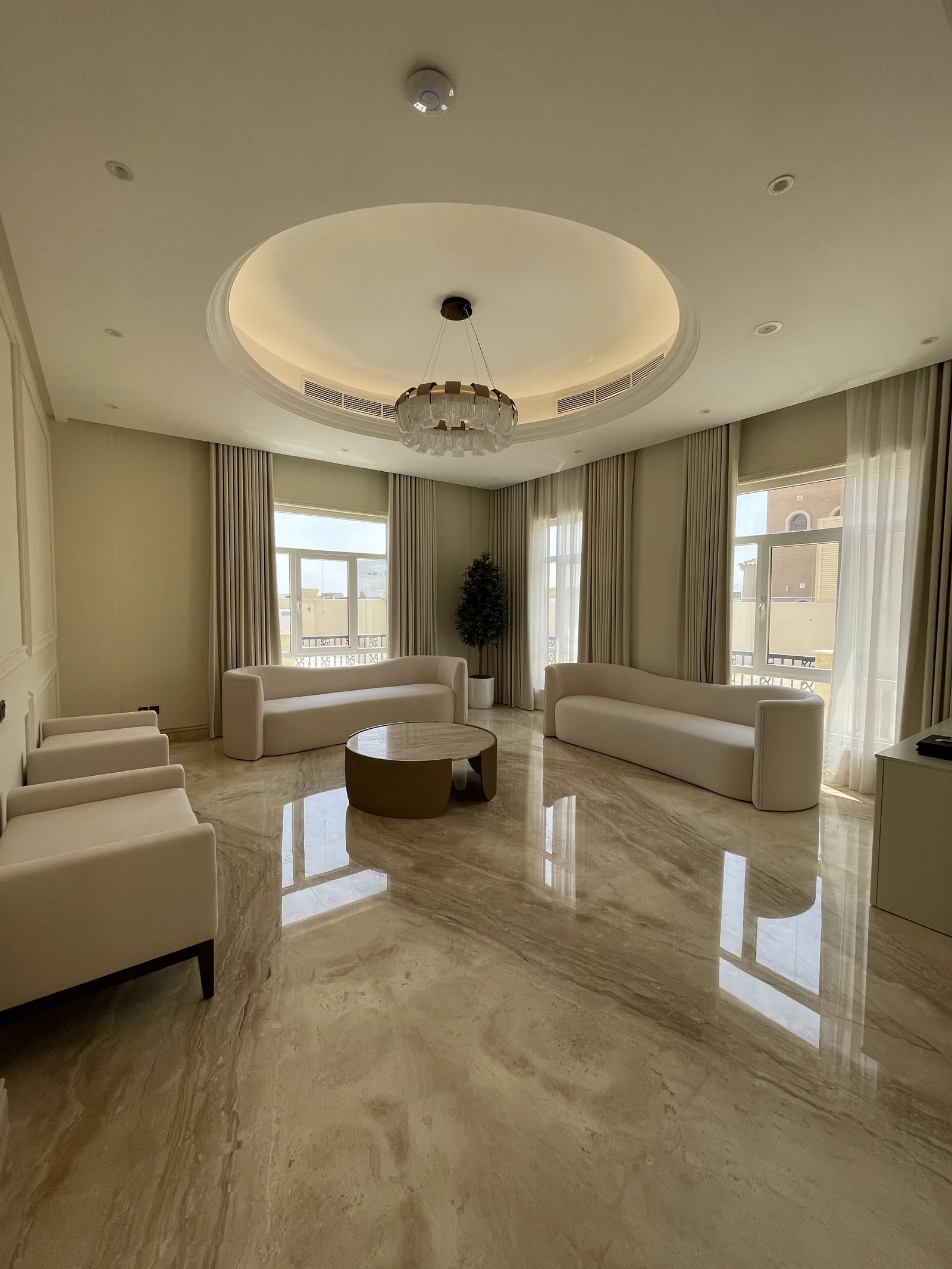 Sitting-room overview with curved sofas and circular ceiling recess.