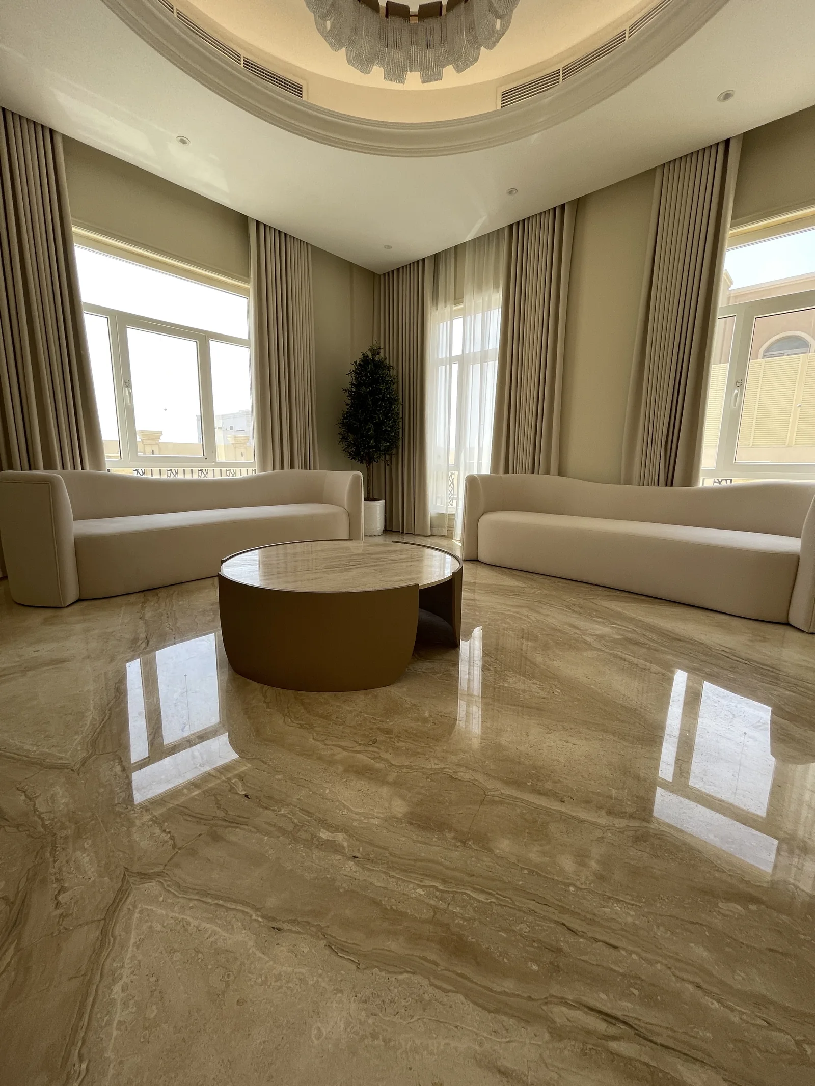 Low view of curved sofas and round coffee table.
