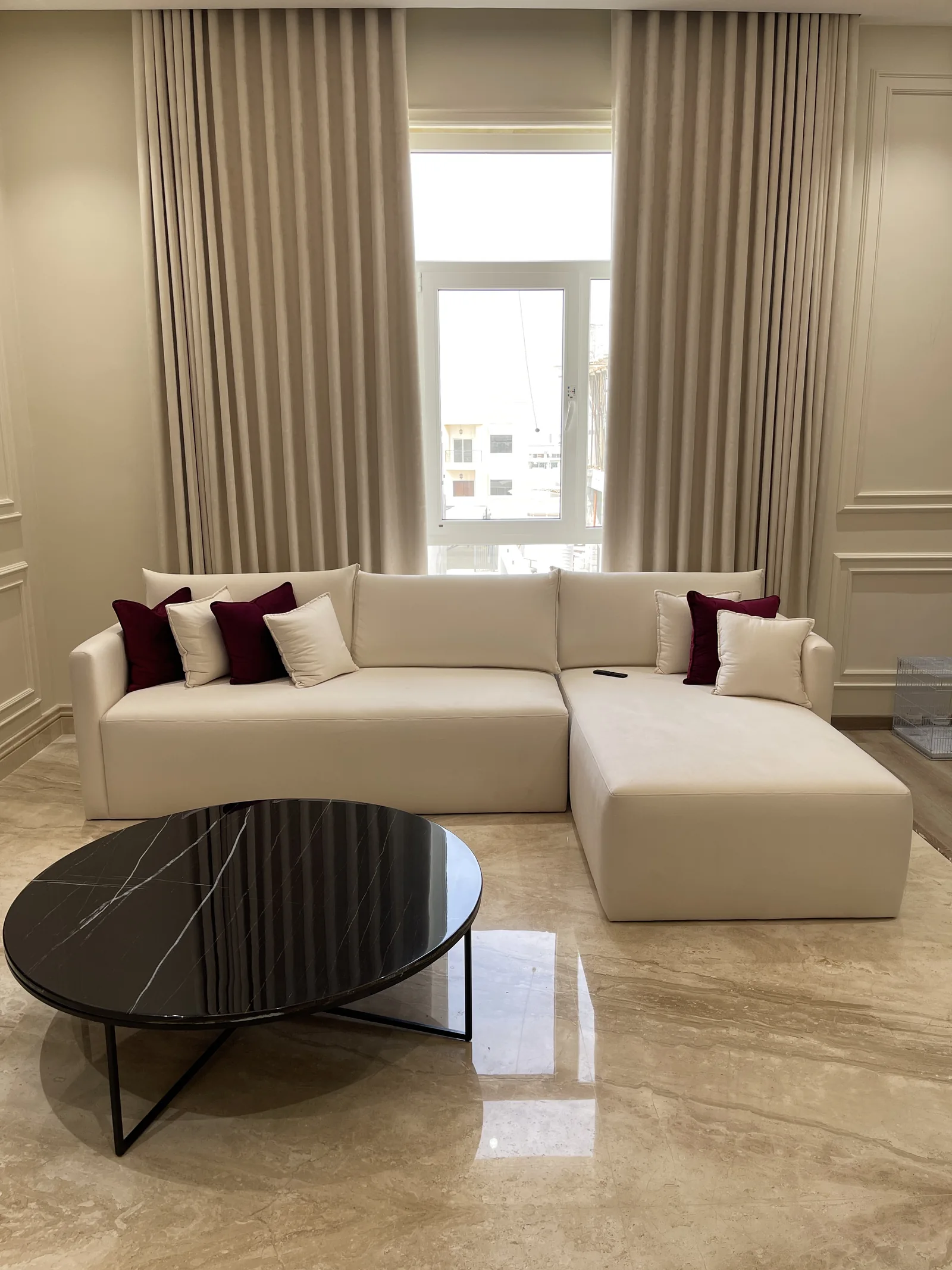 White sectional and black circular coffee table.