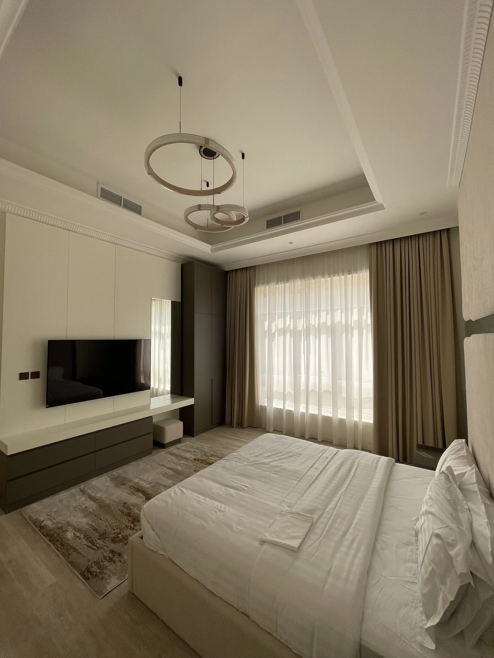 Bedroom overview toward fitted TV and dressing wall.