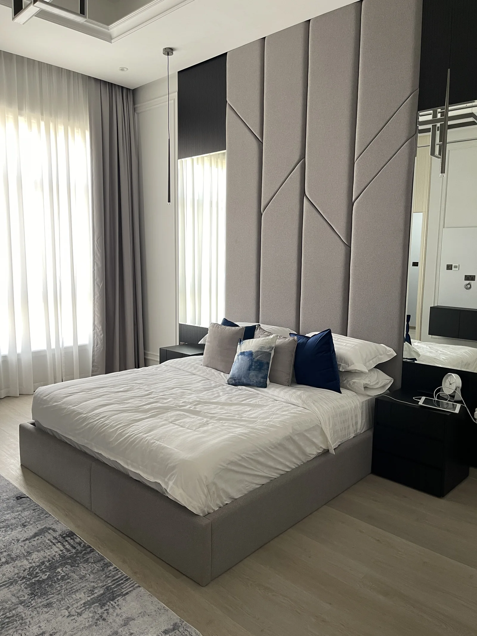Upholstered headboard, mirrored flanks and bedside detail.