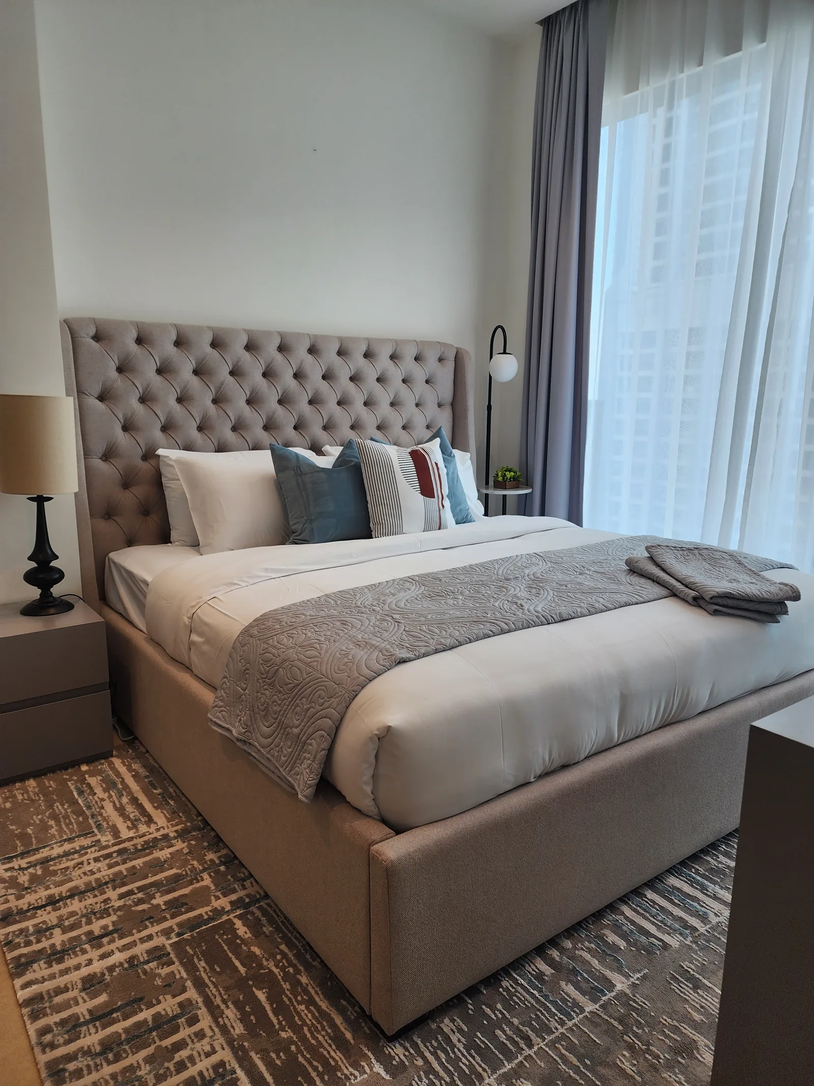 Tufted bed with coordinated bedside furnishings.