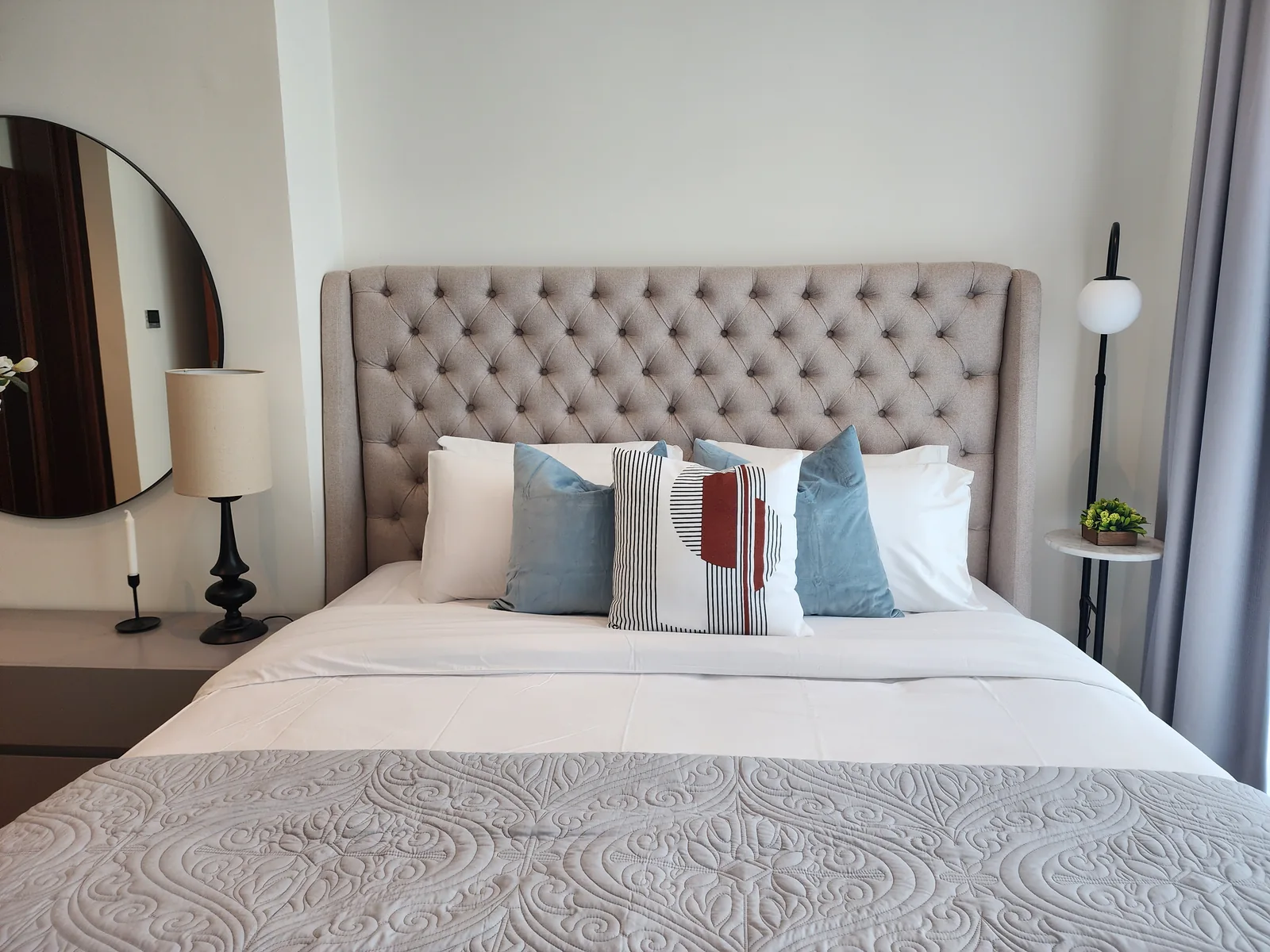 Frontal tufted headboard and layered bedding.
