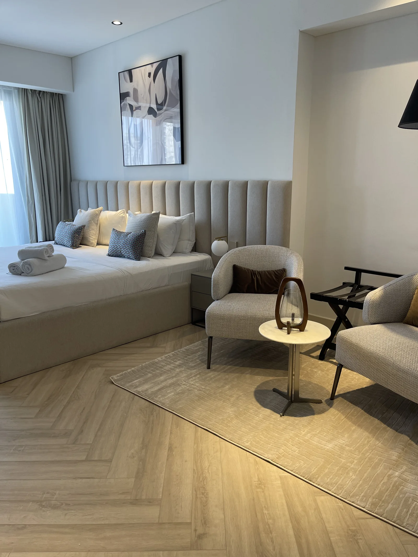 Channelled headboard, bed and compact lounge seating.