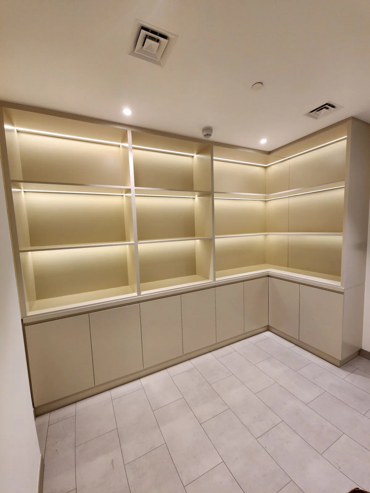 Full-height illuminated corner shelves and low storage.