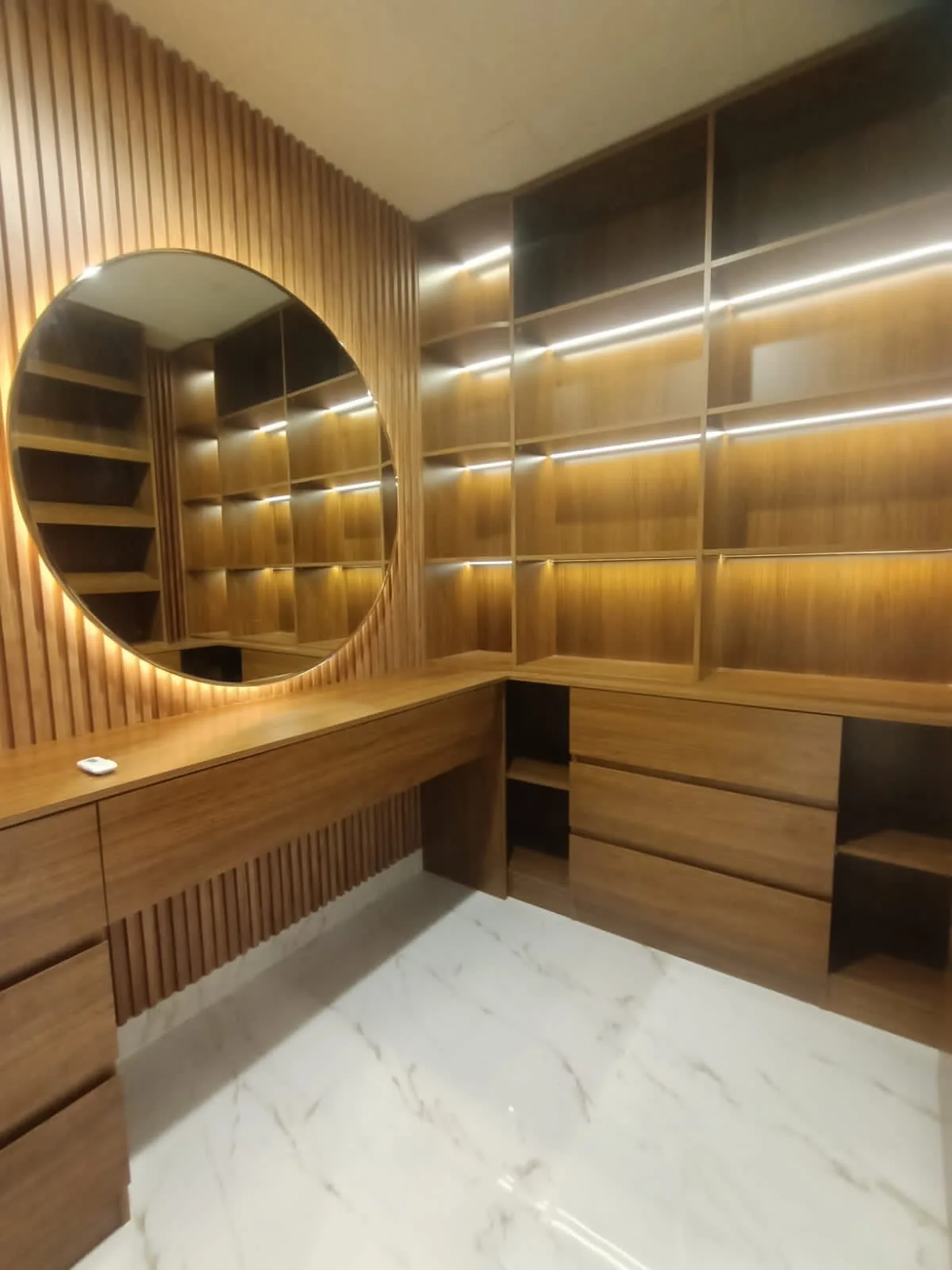 Corner view of integrated dressing table, shelves and drawers.