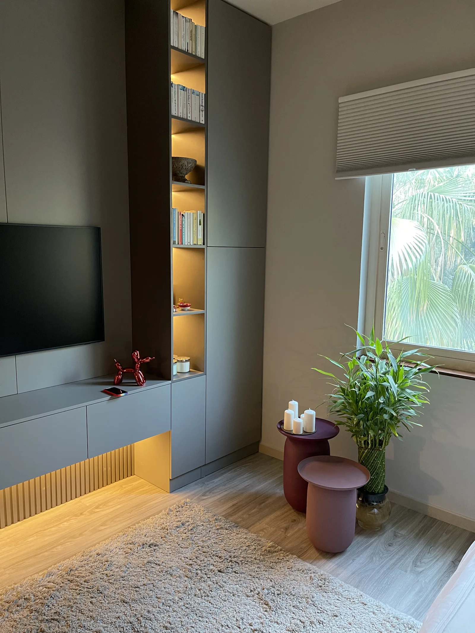 Tall cabinet, illuminated display niche and side-table detail.