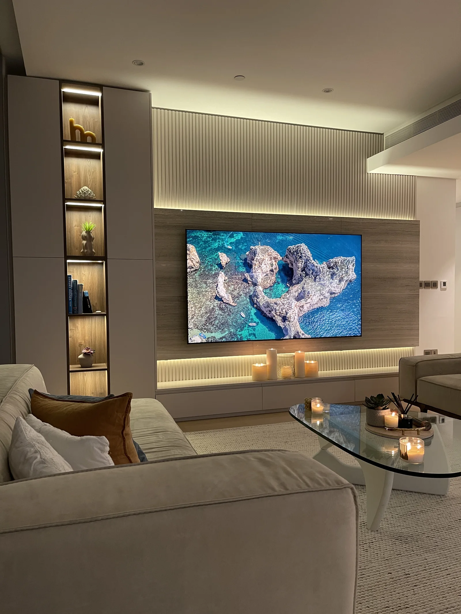 Stone-effect media panel, fluted wall and illuminated display cabinet.