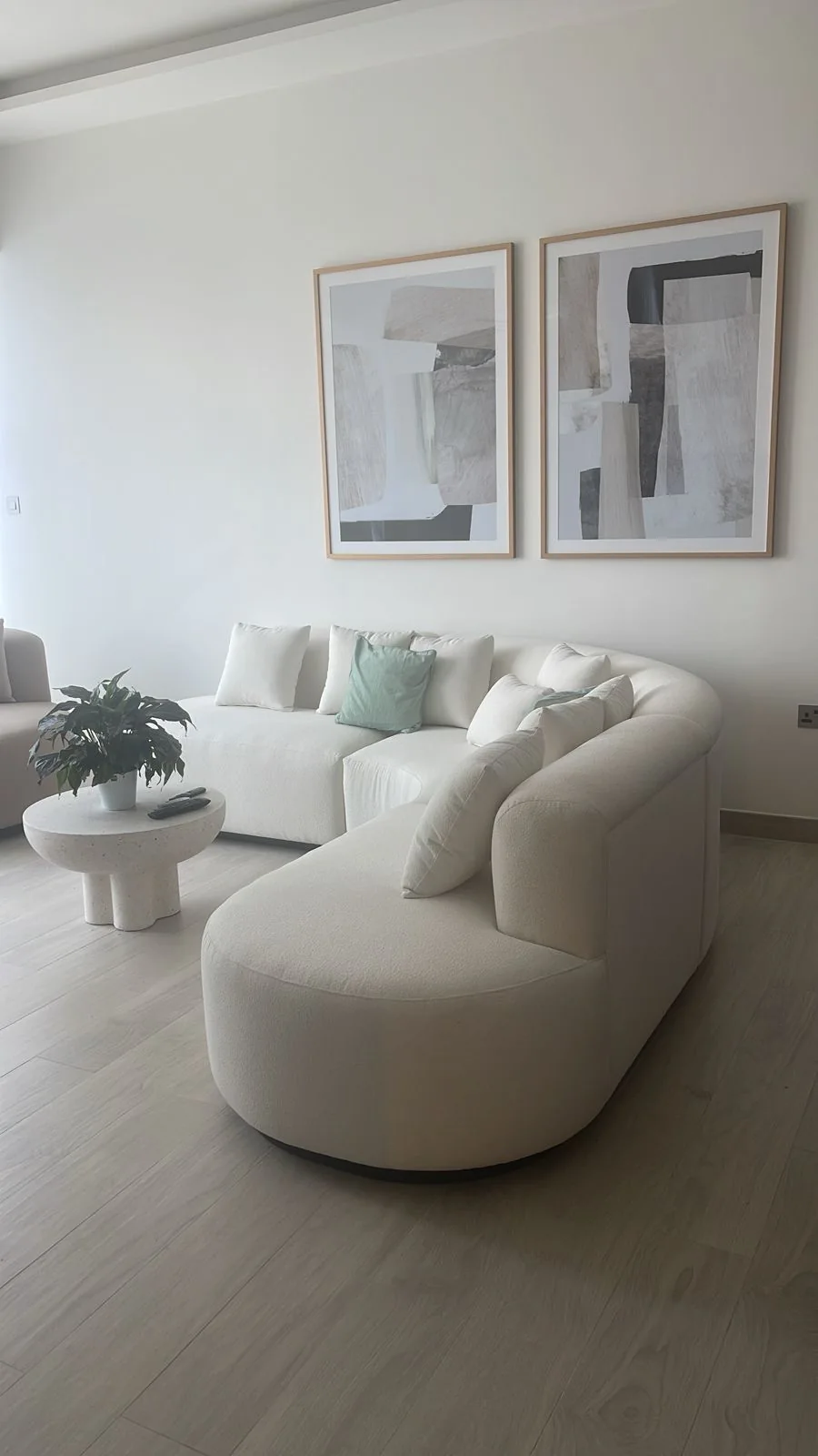 Curved cream sofa with matching low stone-look table.