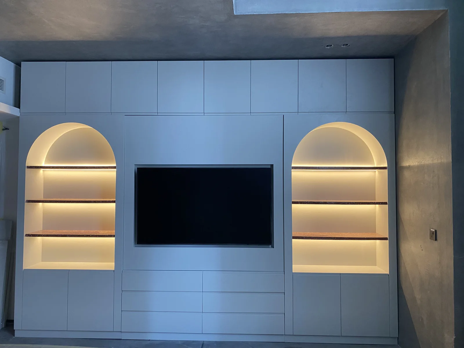 Symmetric arched display niches and fitted media wall.