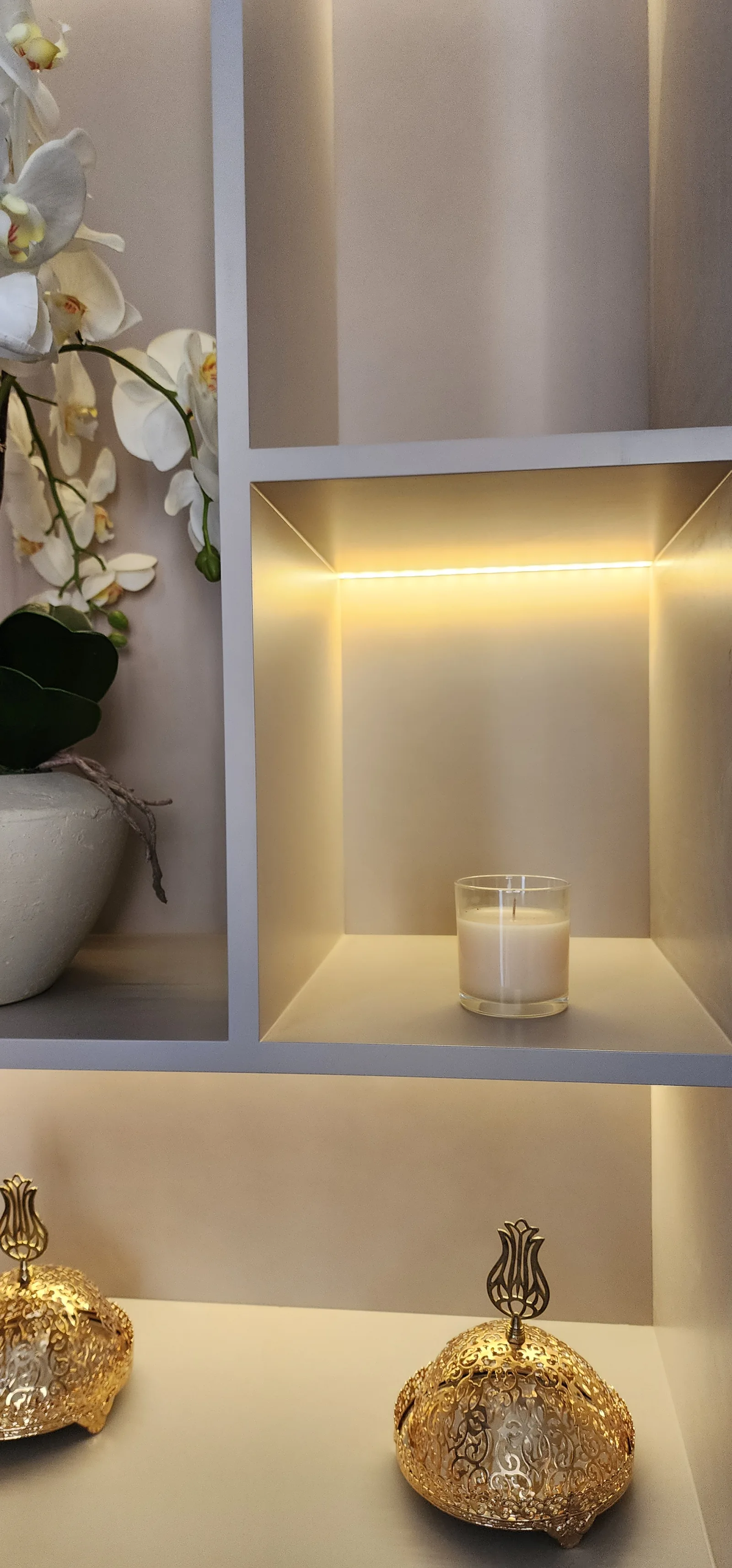 Close view of lit shelf construction and candle niche.