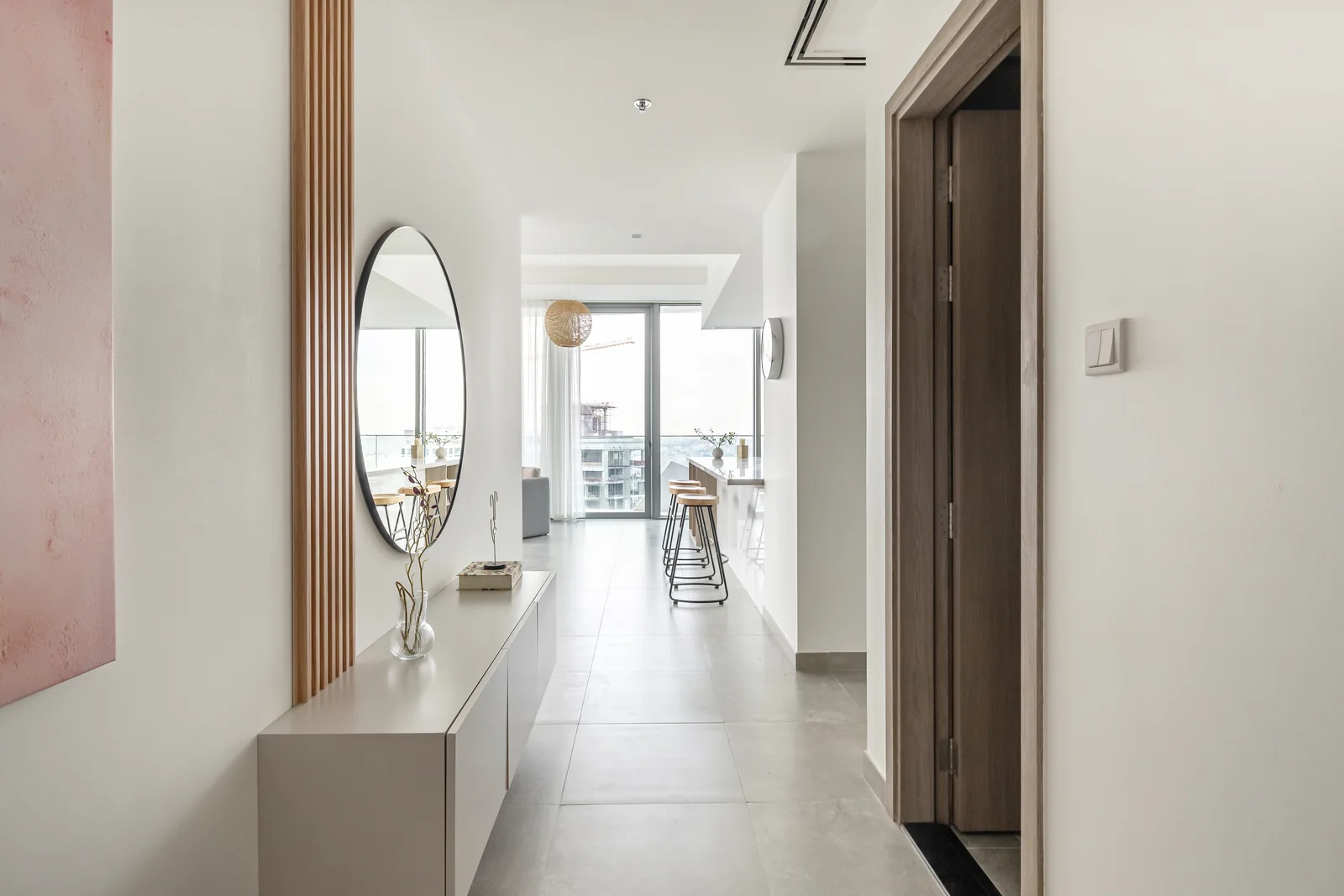 Entrance console, slatted timber-toned feature and round mirror.