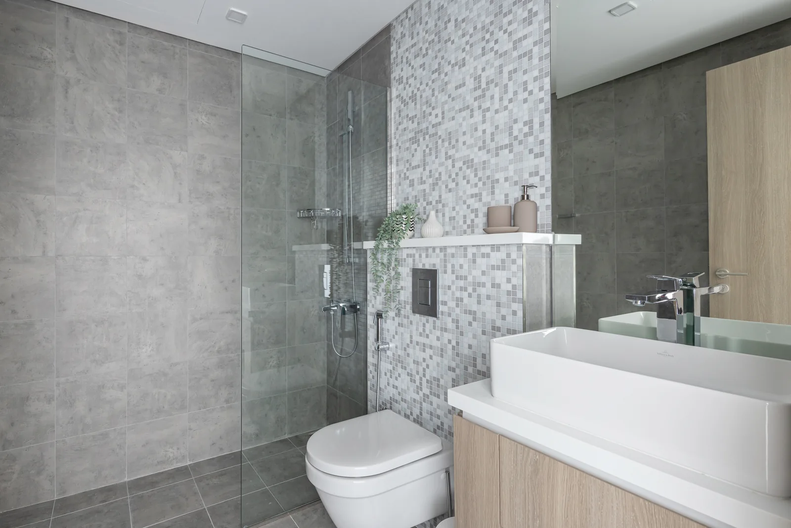 Mosaic-tiled bathroom and timber-toned vanity.