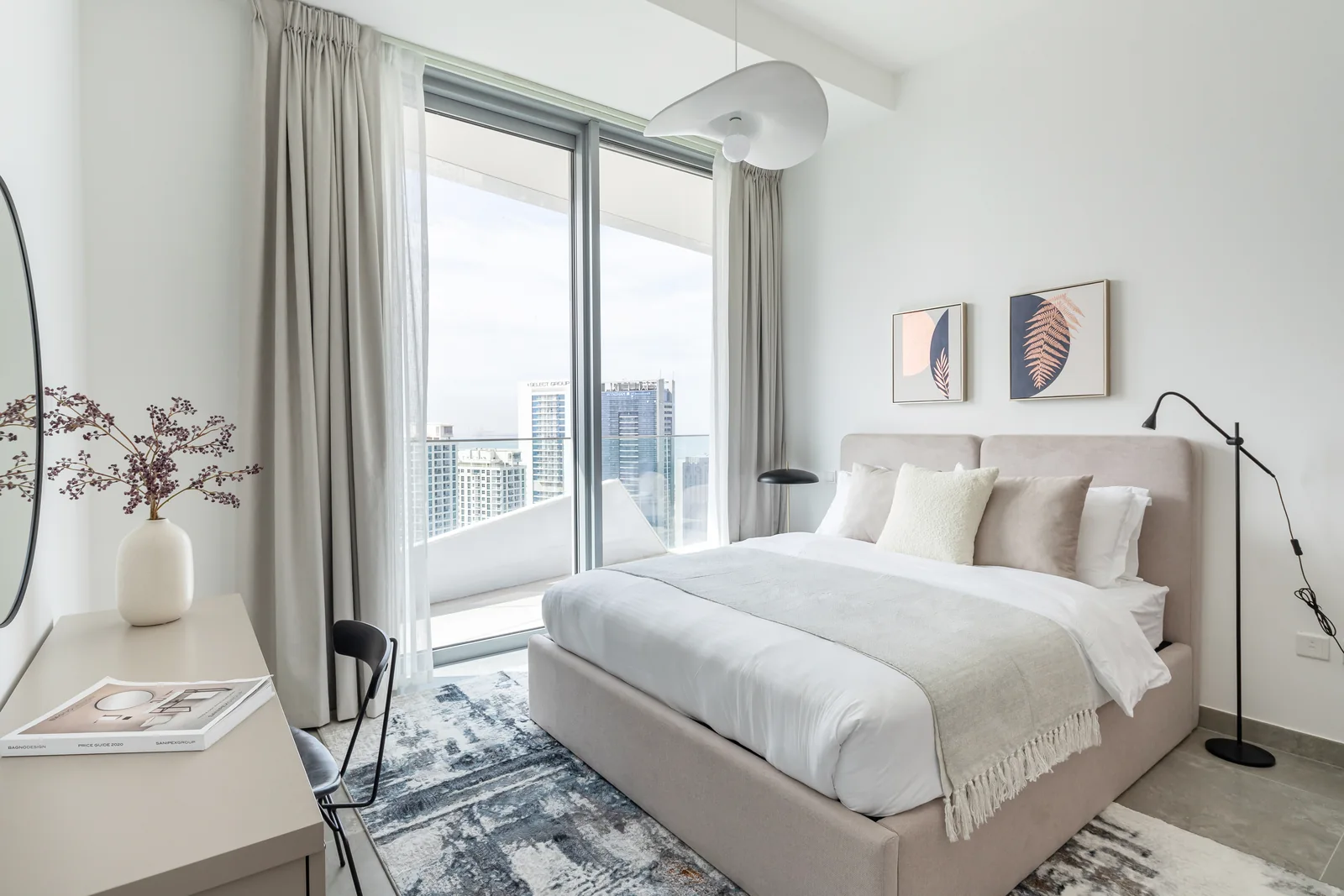 Second bedroom with pale upholstery and sculptural pendant.