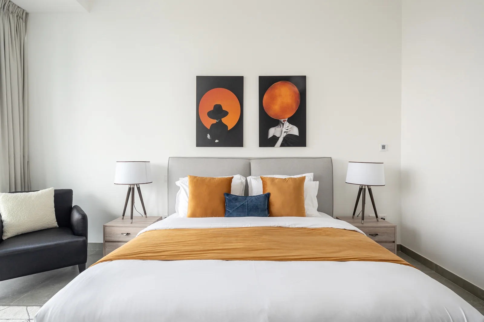 Ochre-accent bed, lamps and symmetrical bedside tables.