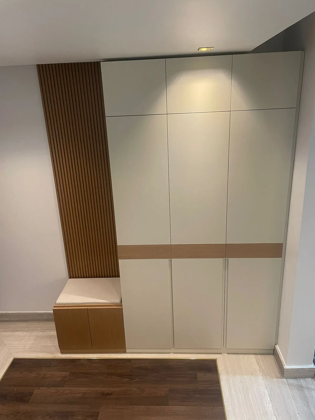 Tall entry storage with integrated bench and slatted panel.