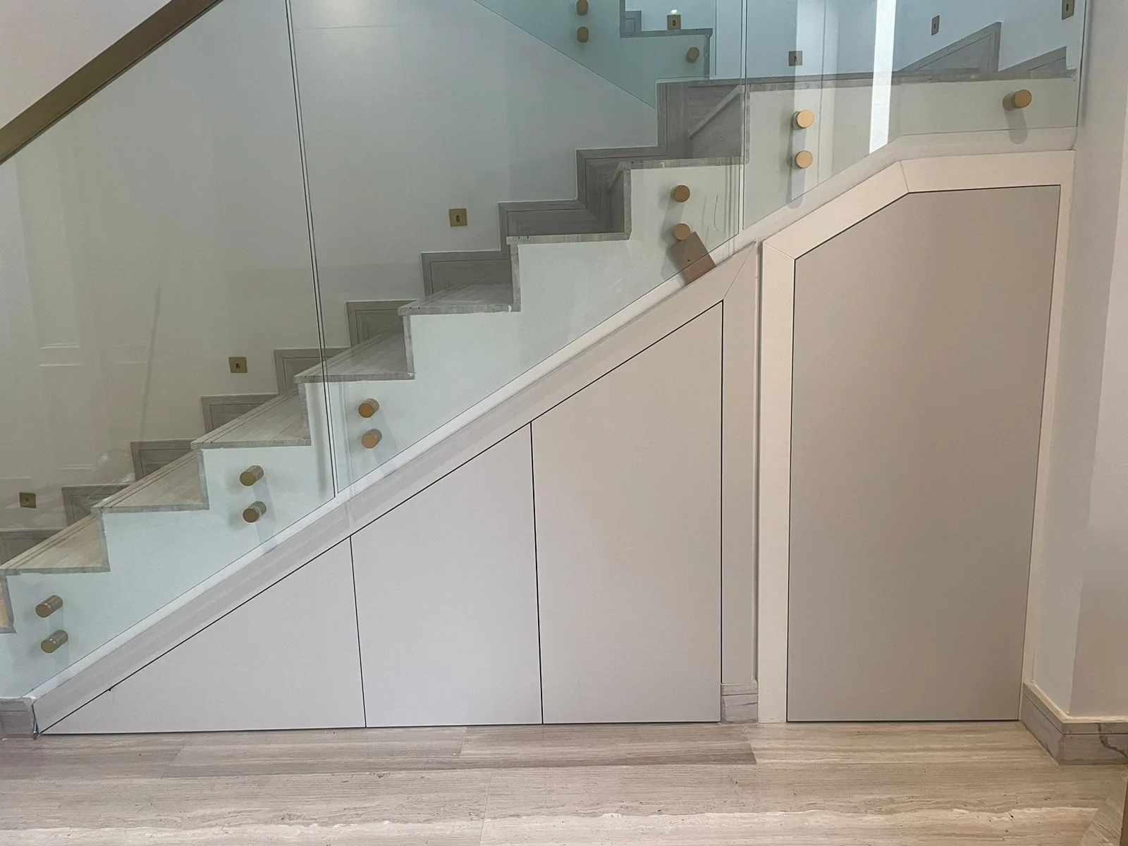 Under-stair fitted cupboards following the stair profile.