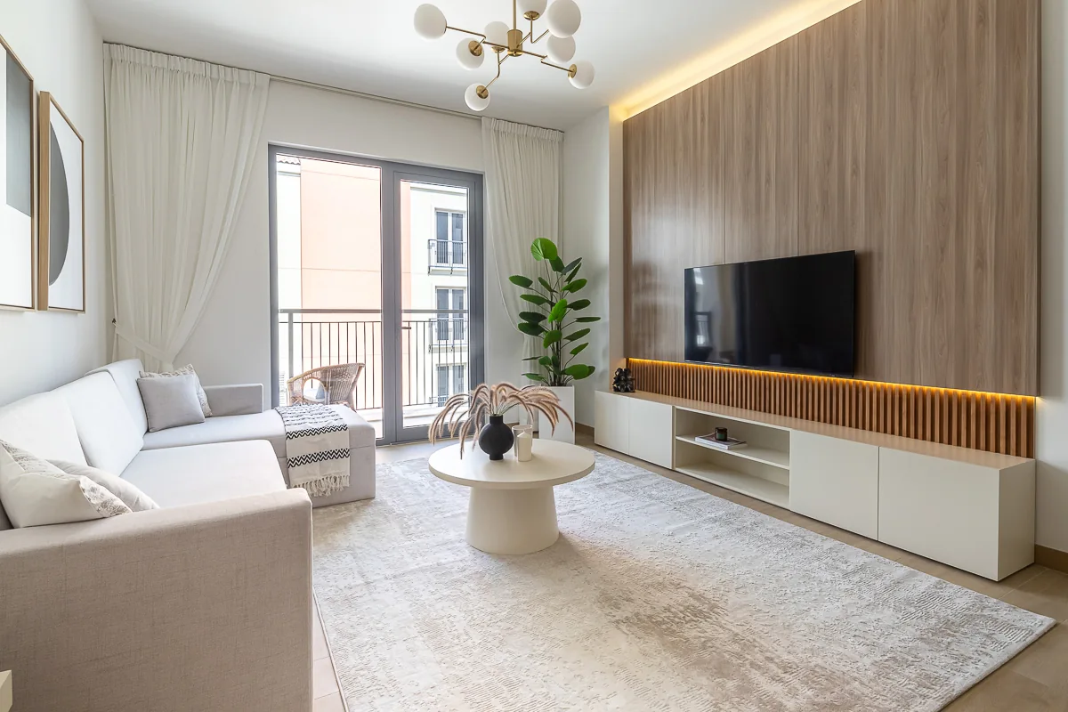 Living room and illuminated pale-timber-toned TV wall.