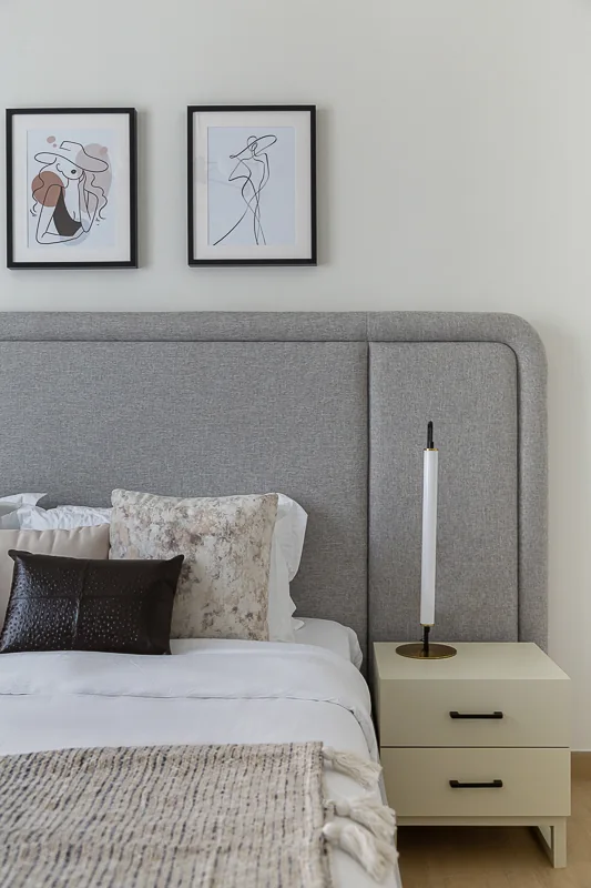 Upholstered headboard and bedside lighting.