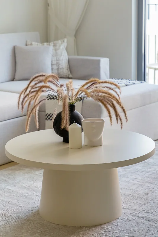 Round pedestal coffee table and sculptural vessels.