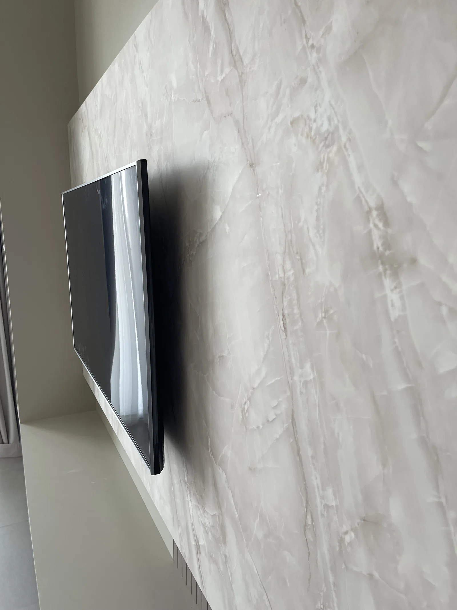 Close view of the veined TV-wall panel surface and its edge.