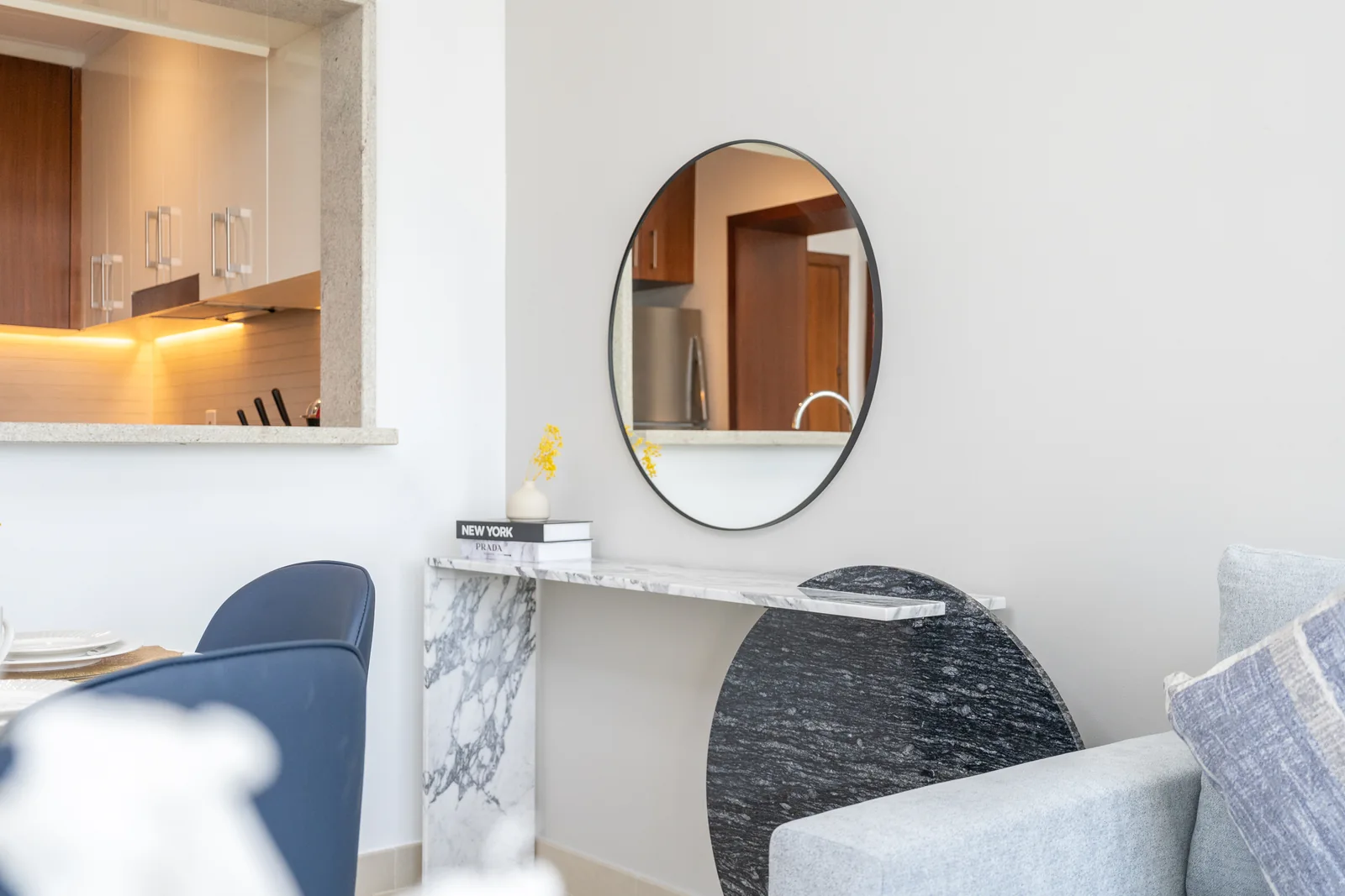 Patterned console table with a circular dark panel and round mirror.
