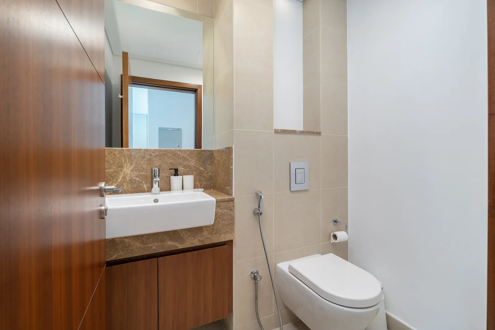 Compact powder room with timber-toned vanity and brown surfaces.