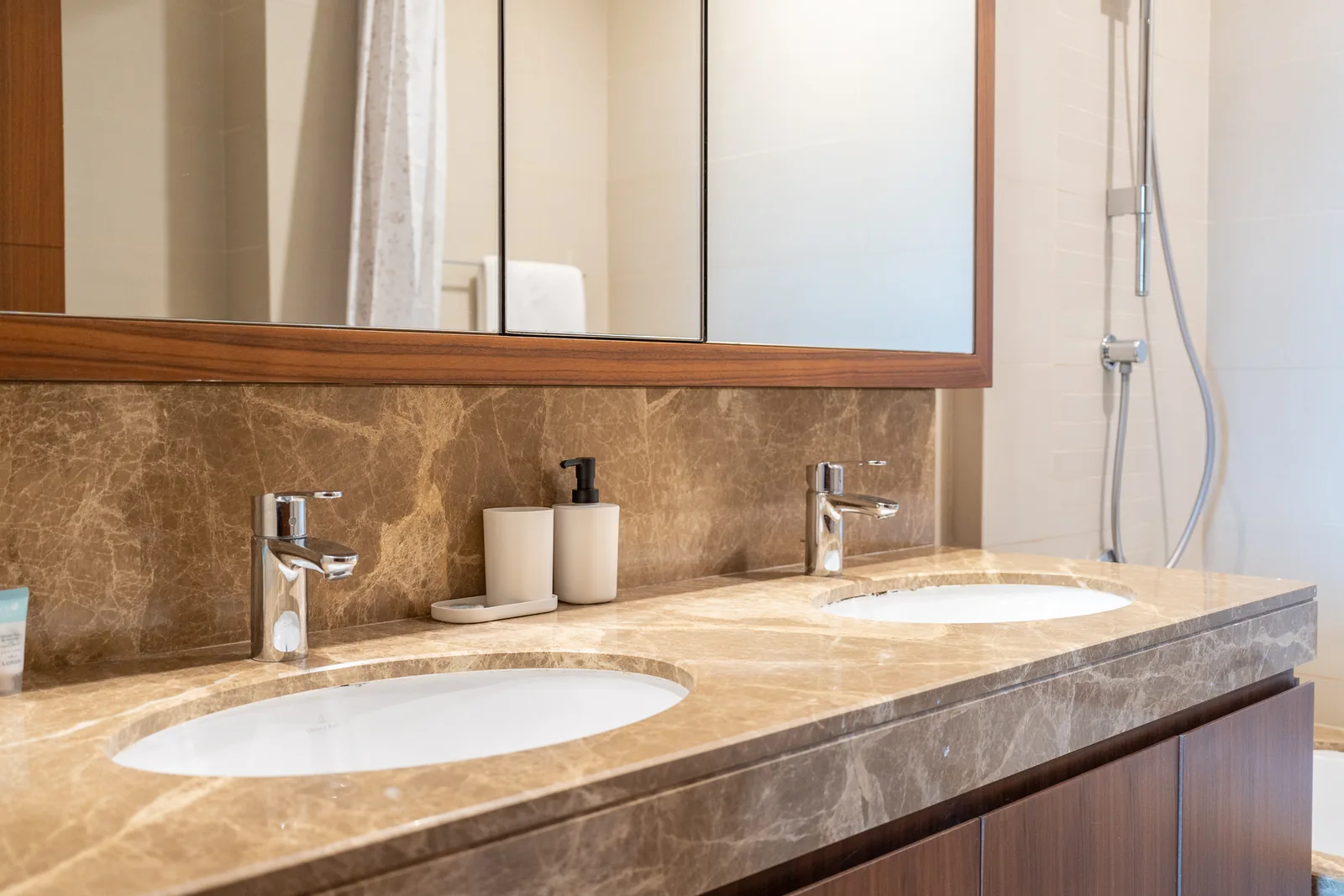 Double-vanity basins, taps, counter and timber-toned-framed mirror.