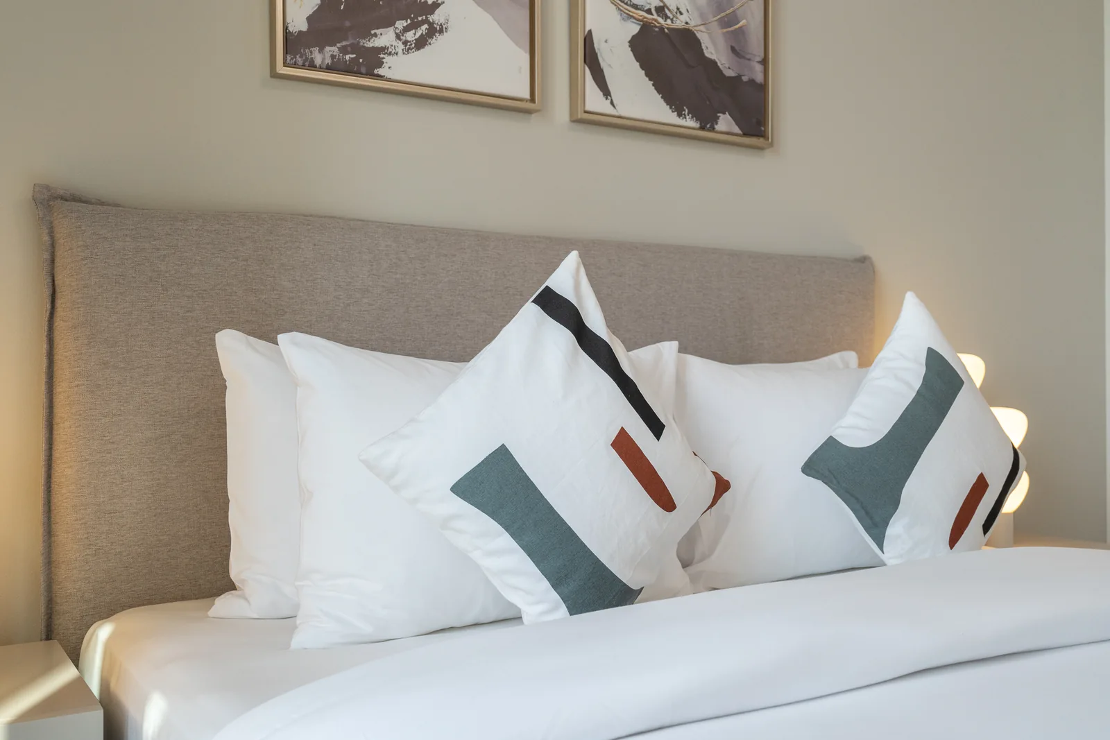 Upholstered headboard and geometric accent cushions.