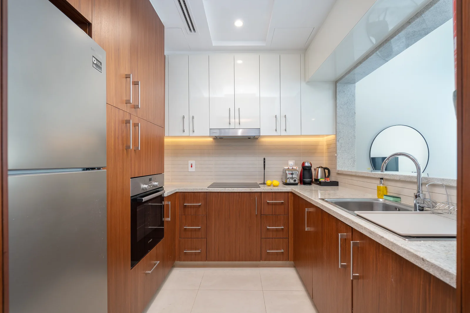 Timber-toned and white kitchen cabinetry with under-cabinet lighting.