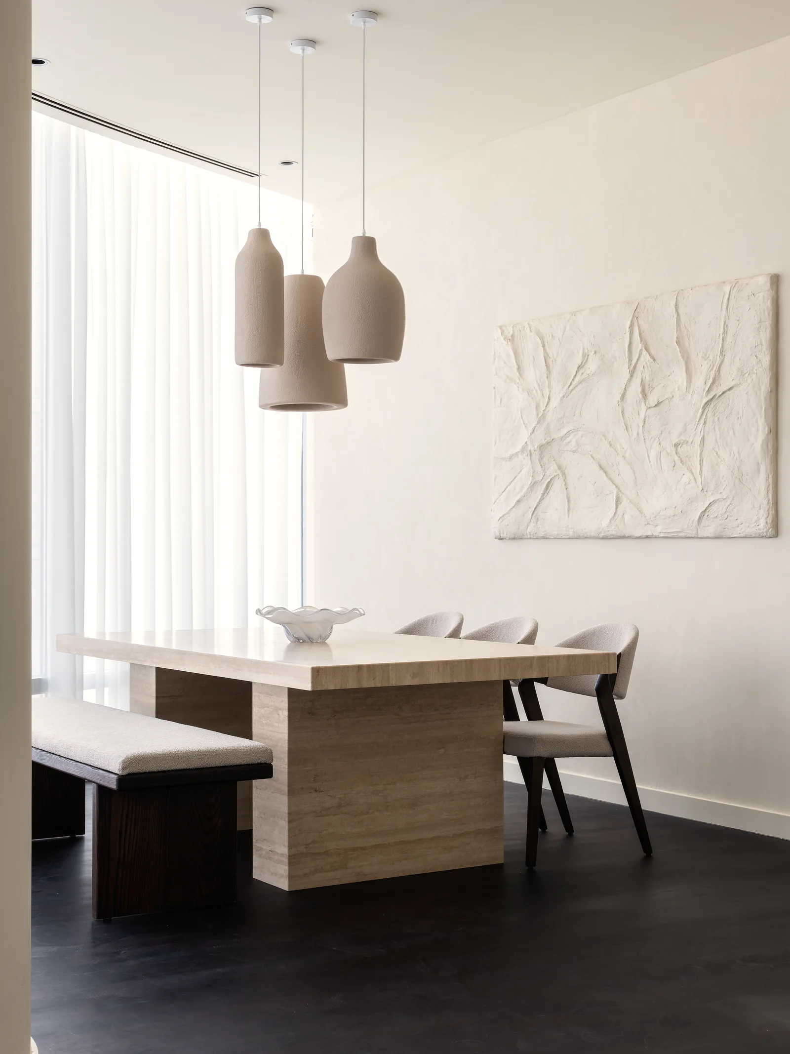 Dining table, bench, pendant lights and relief artwork.