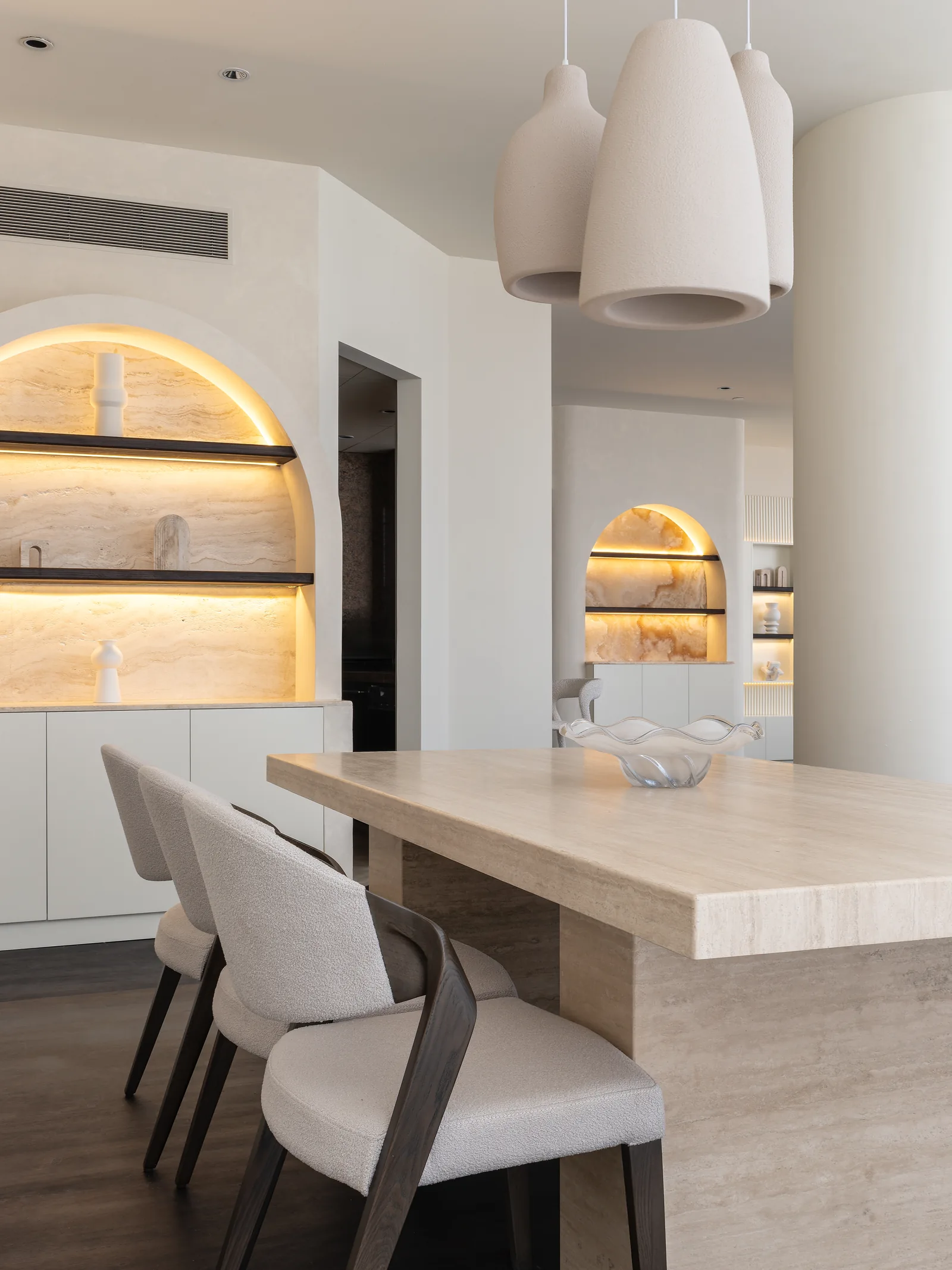 Dining furniture and illuminated arched display cabinetry.