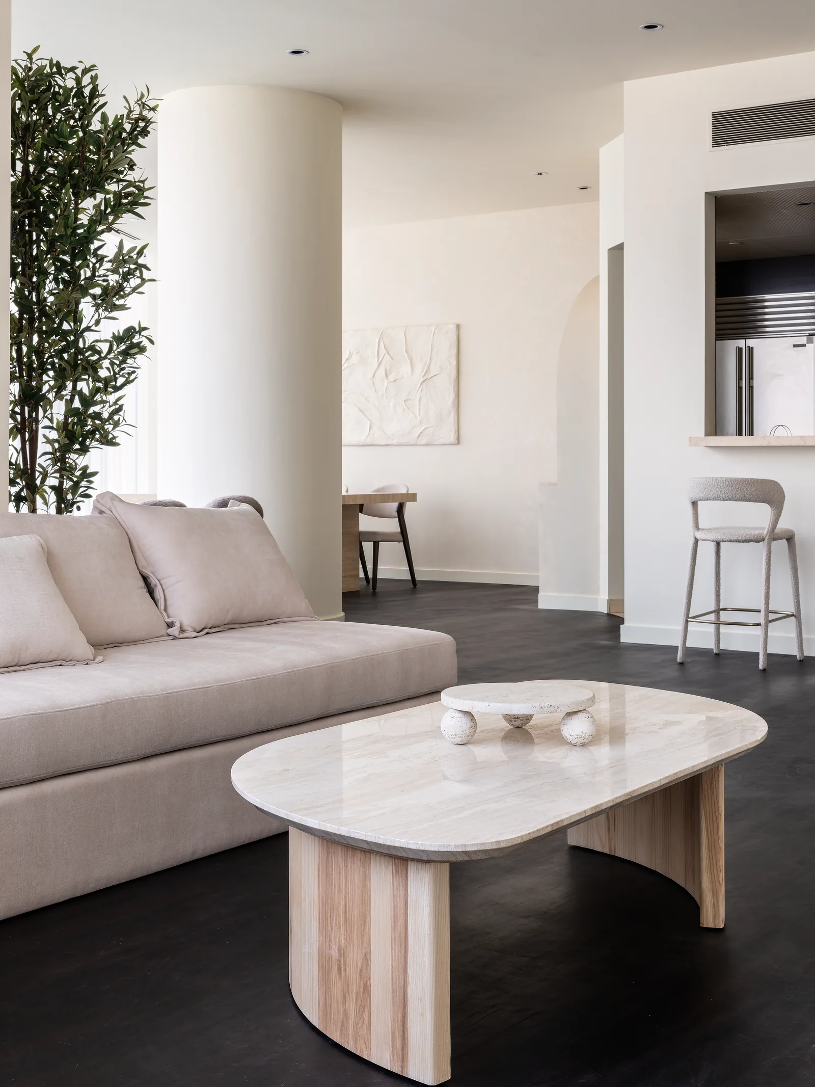 Sofa, sculptural coffee table and kitchen pass-through.