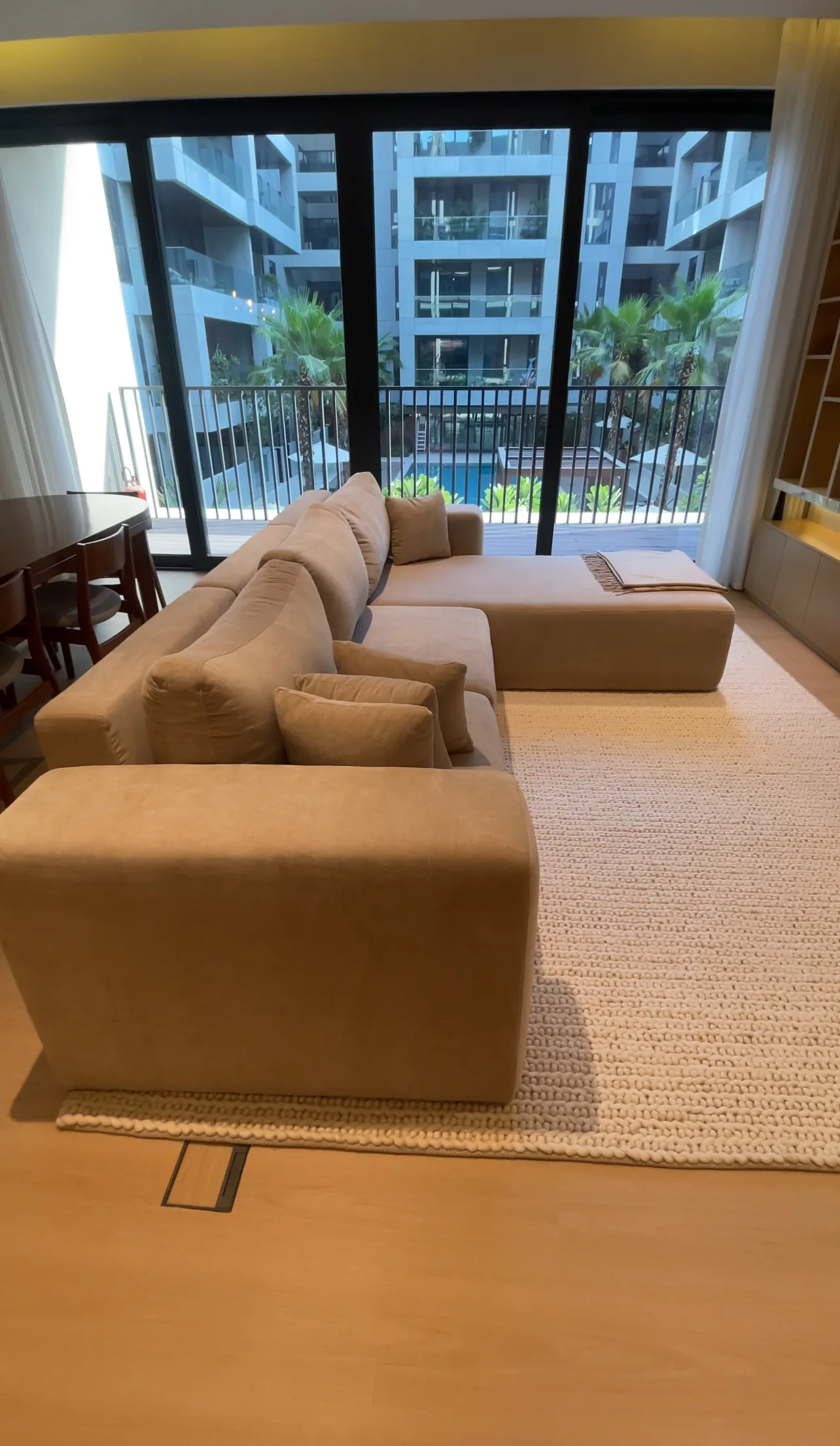 Sectional sofa with a chaise beside full-height glazing.